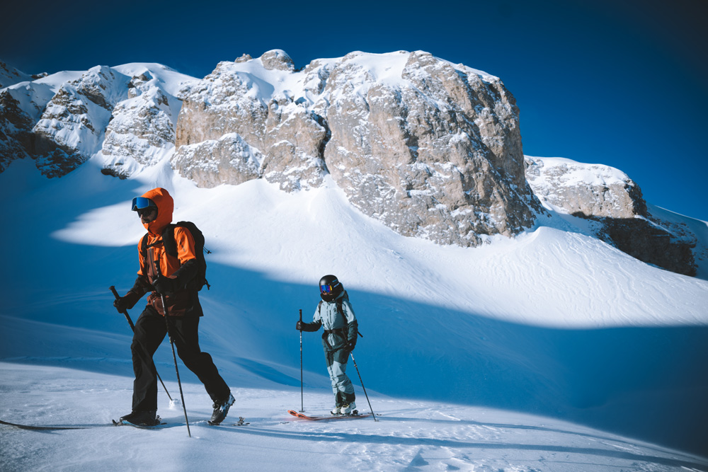 Ski touring in the Avals Valley in Courchevel, with skiers making their way through a snowy valley surrounded by alpine peaks.
