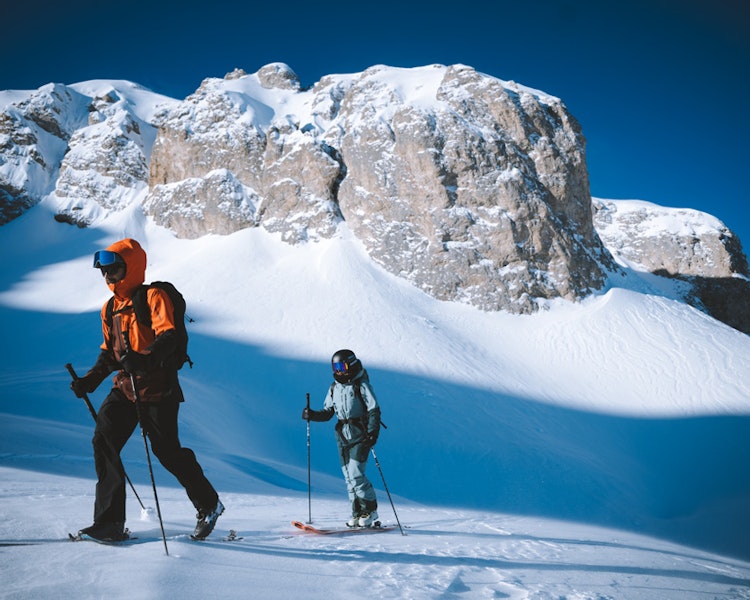 Ski touring in the Avals Valley in Courchevel, with skiers making their way through a snowy valley surrounded by alpine peaks.