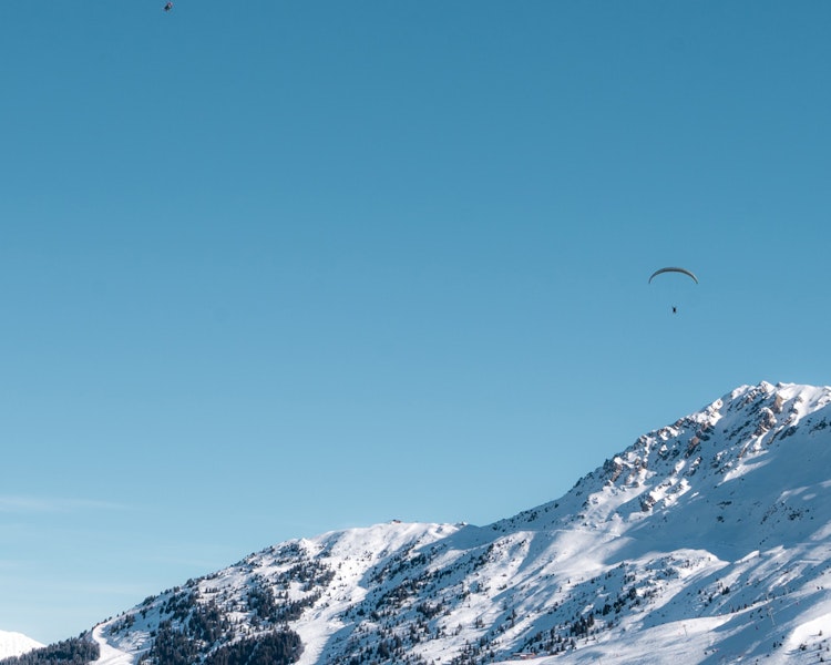 Two paragliders in the air at Col de la Loze in Courchevel
