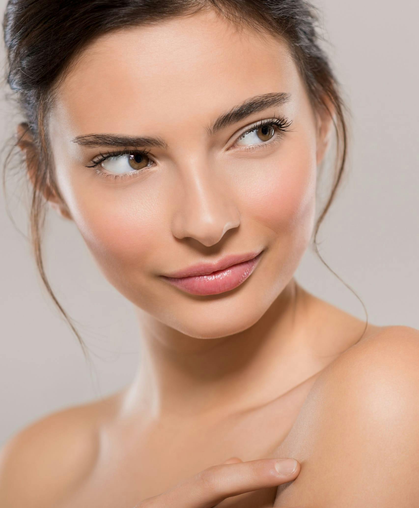 Model smiling with bare shoulders.