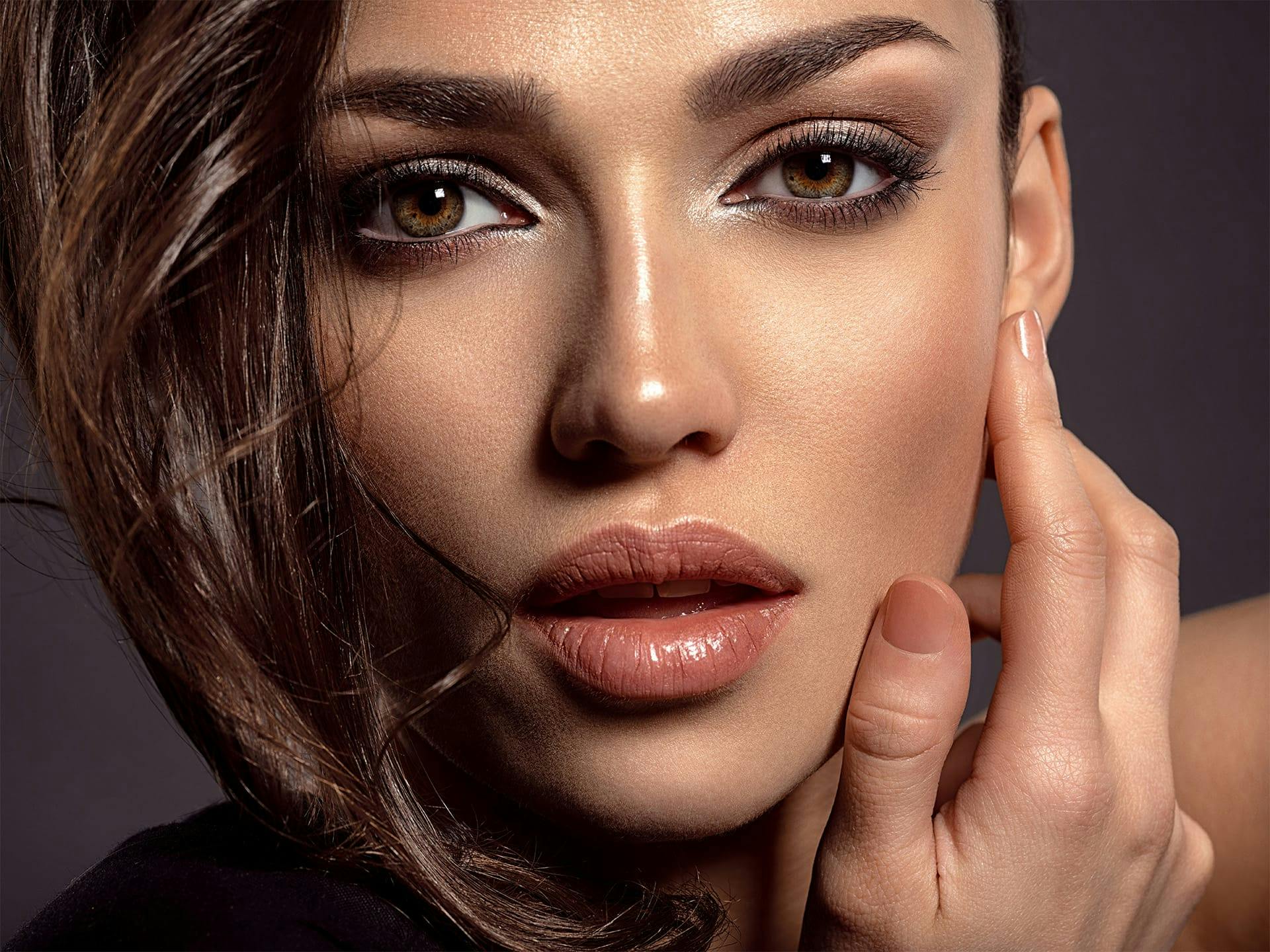 Closeup of a model's face with her hair covering one side.