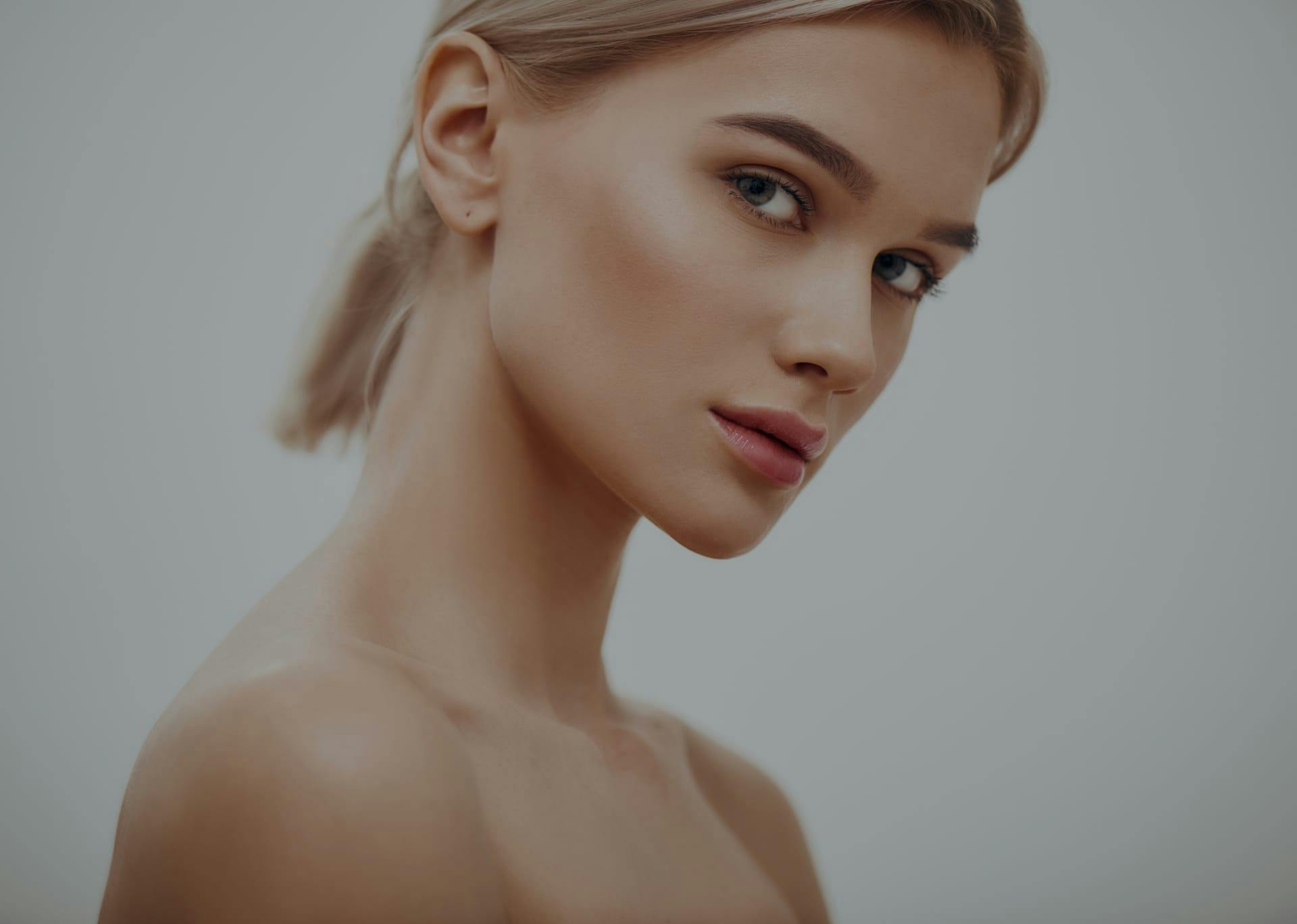 Model with bare shoulders looking towards the camera.