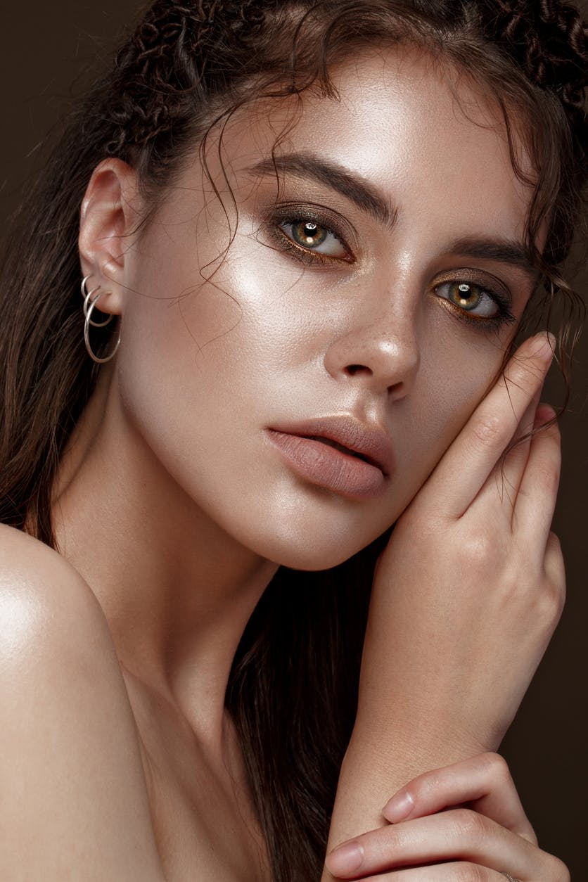 Close-up of a brunette woman touching her face