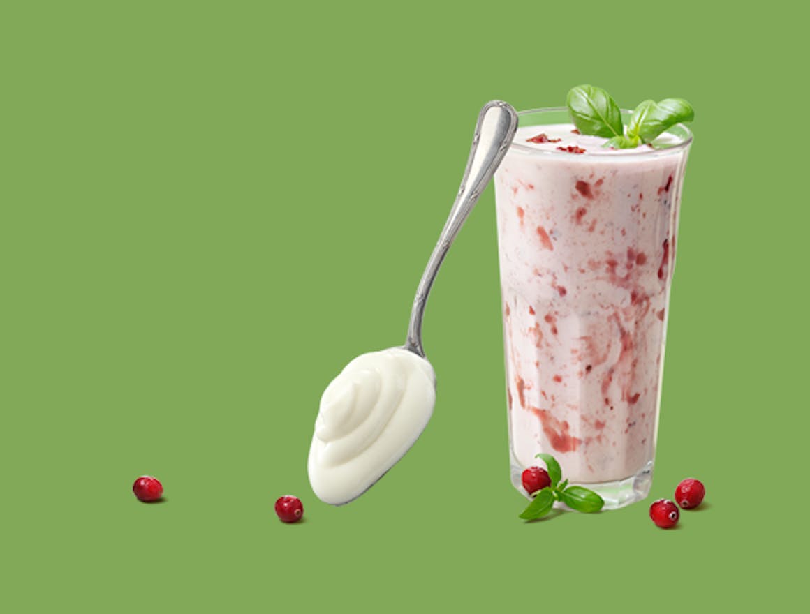 Glas met Melkunie magere yoghurt met besjes.