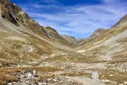 Suvrettapass, karge Landschaft mit blauem Himmel.