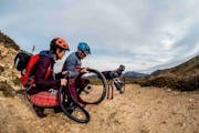 Eine Frau und ein Mann wechseln den Schlauch an ihrem Mountainbike.