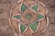 Ein Mandala gelegt im Wald mit Tannzapfen, Stöckchen und Fichtennadeln.
