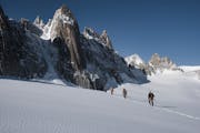 Personnes en train de faire une randonnée en haute montagne. Elles marchent en cordée.