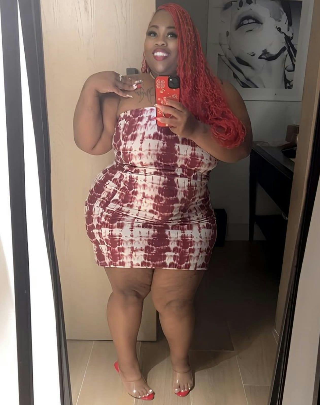 Woman with red hair in a red and white dress