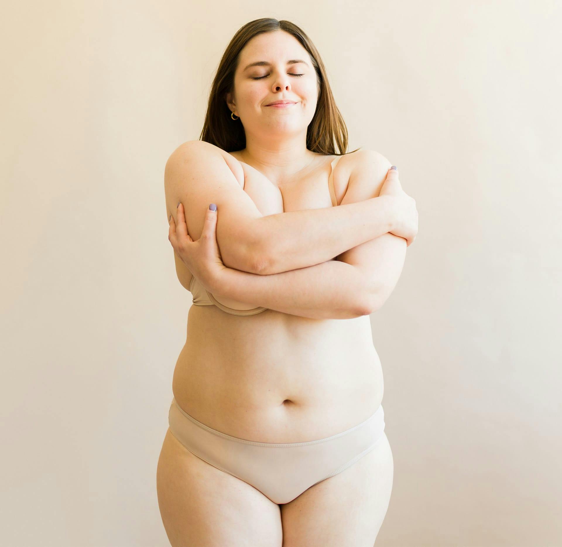 plus size woman covering her breasts with her arms