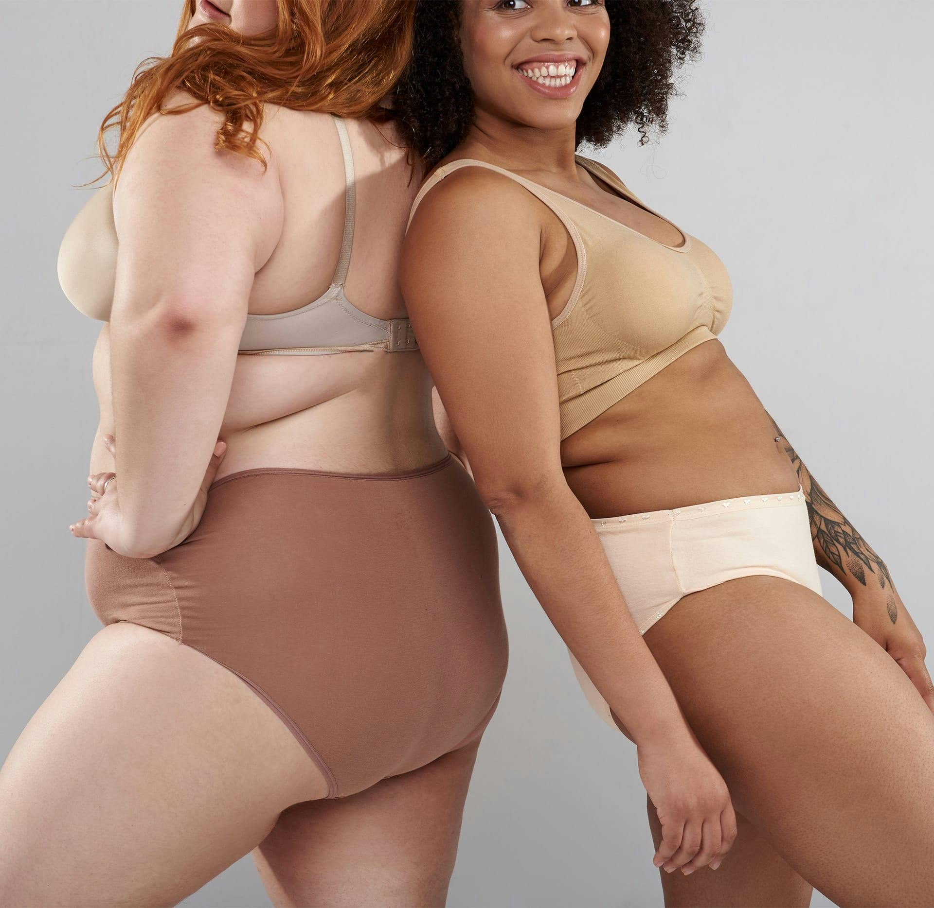 2 woman of different sizes in underwear back to back