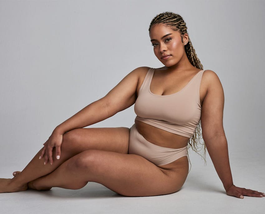 woman sitting on her side with hand on floor and the other near her knee