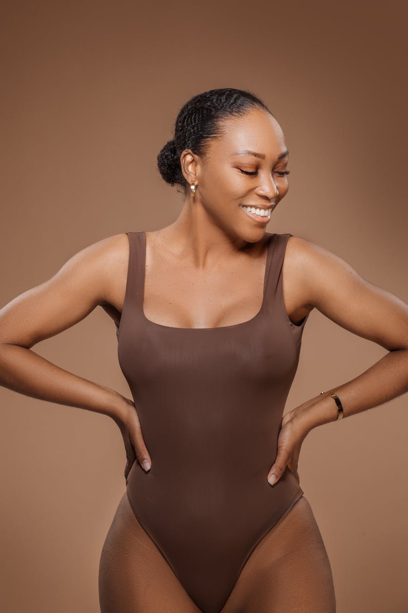 Curvy black woman smiling in body suit