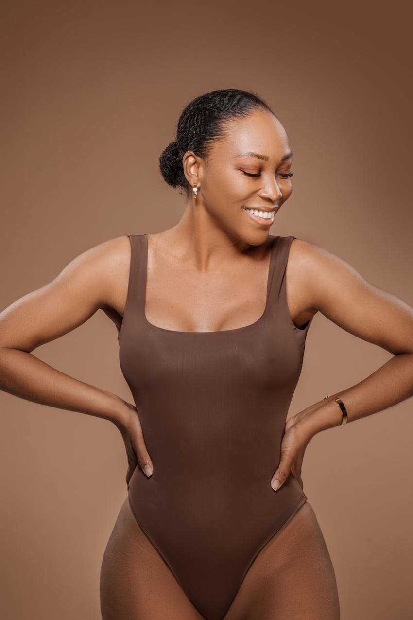Curvy black woman smiling in body suit
