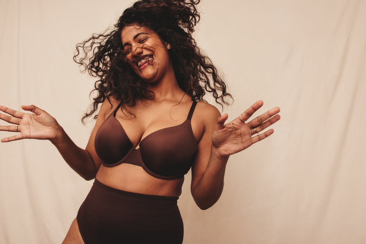 Curvy Woman happily dancing in underwear