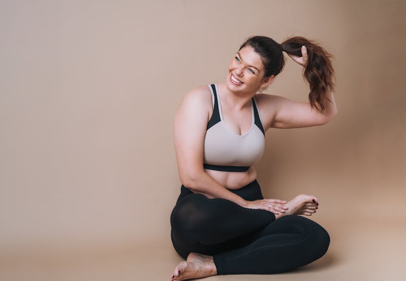 woman sitting down touching her pony tail