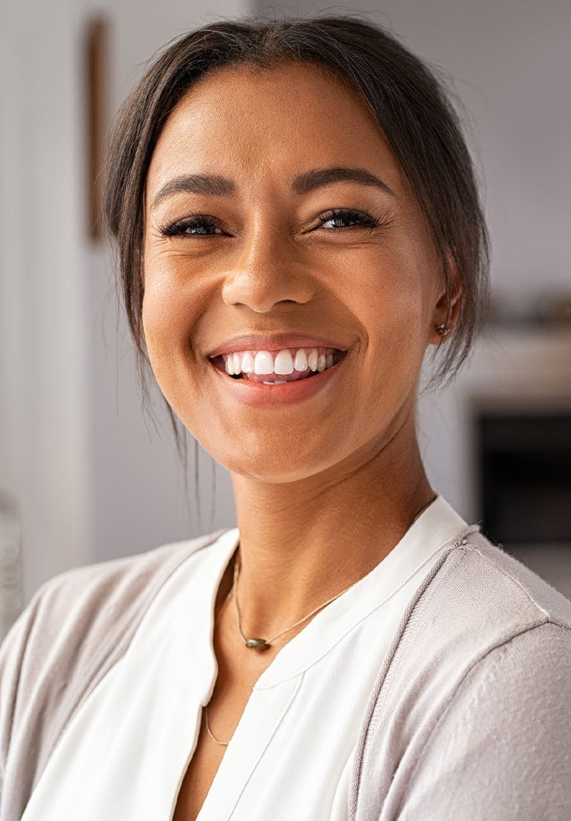 Woman smiling wearing a light colored top