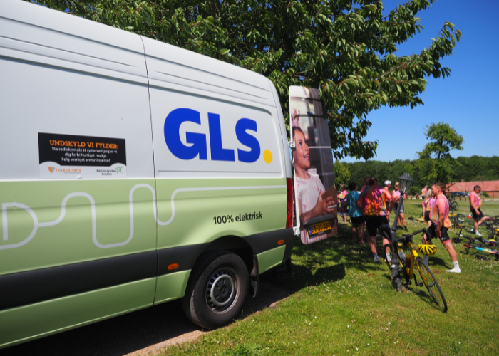 GLS sponsorbil parkeret med cykelryttere ved siden af