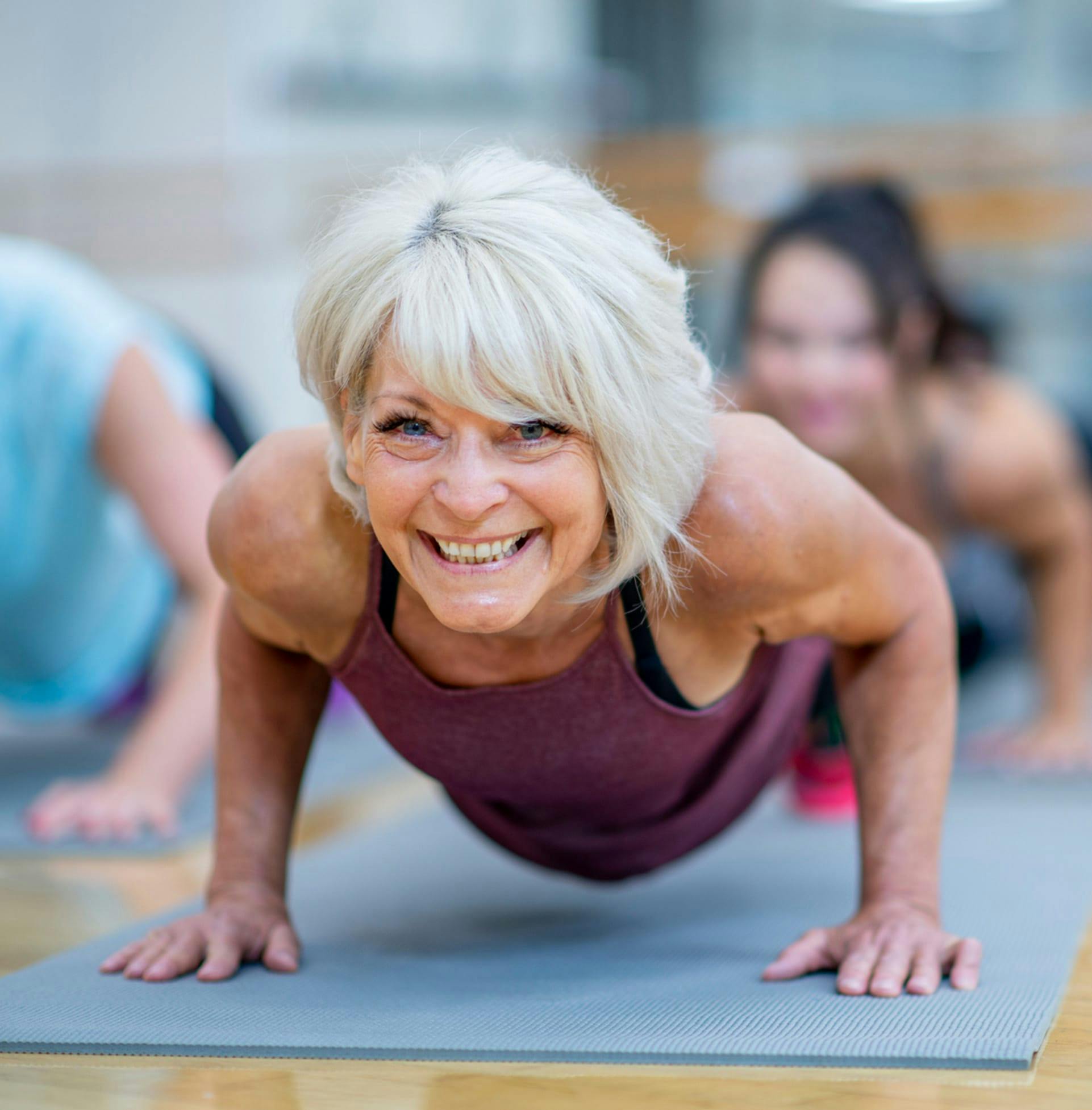 Older woman smiling and doing yoga
