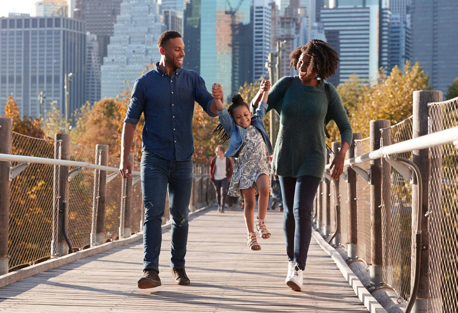 smiling family walking across the bridge