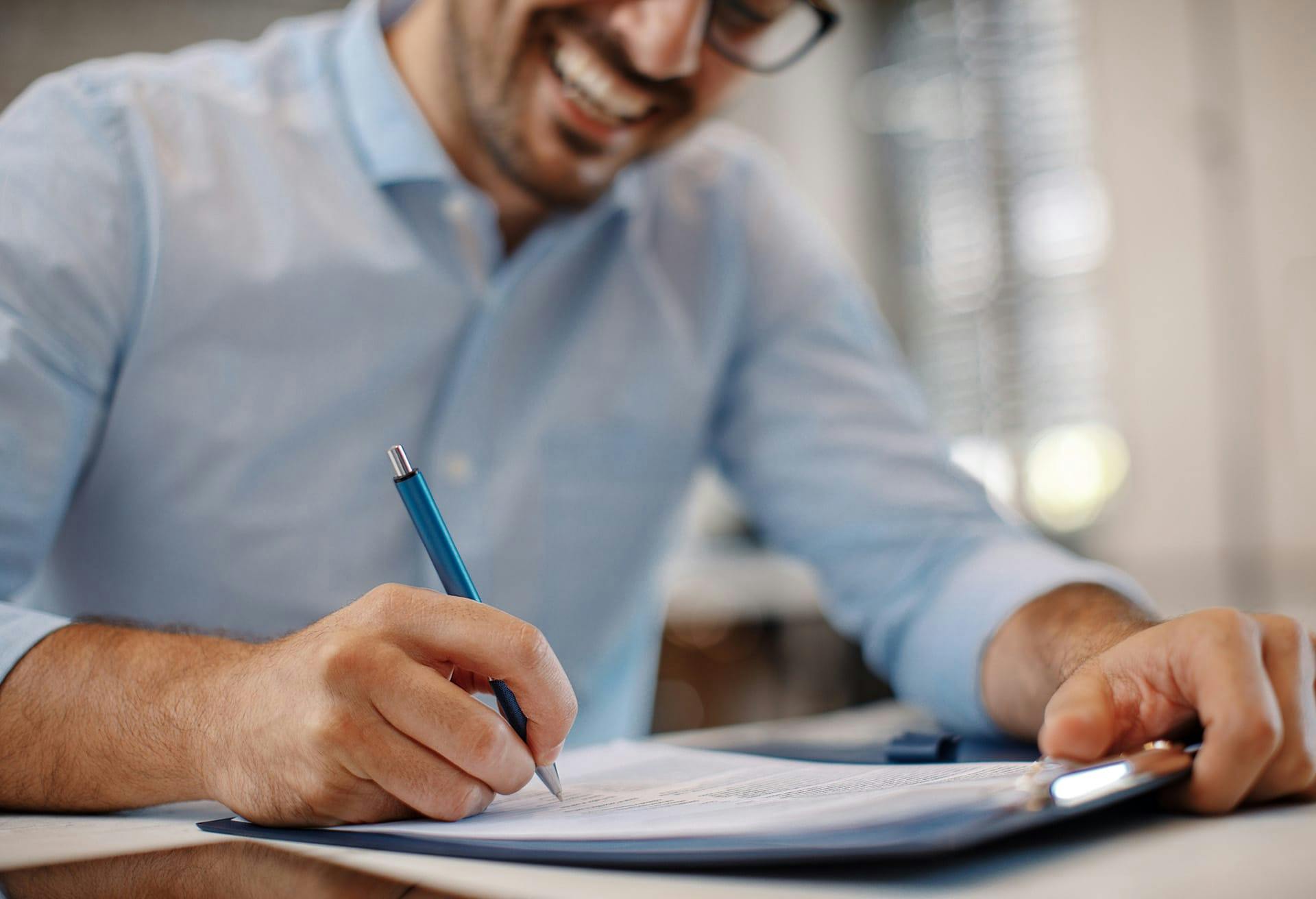 Man Smiling and signing document