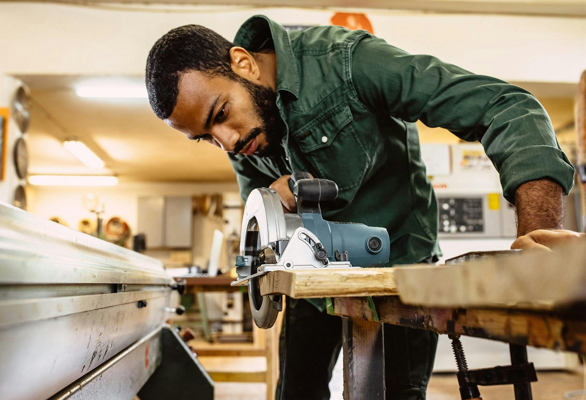 Man cutting wood with saw