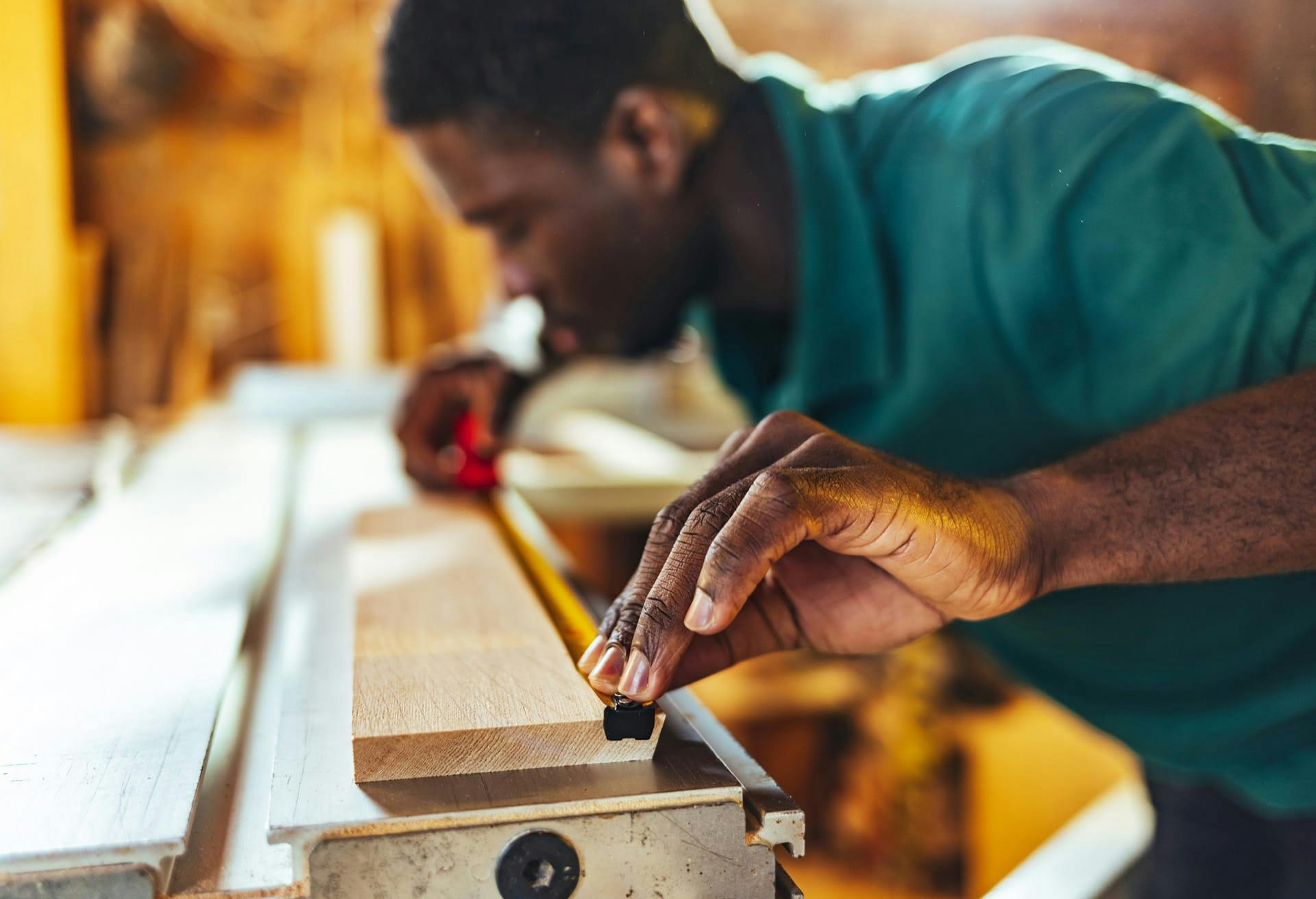 man measuring wood plank