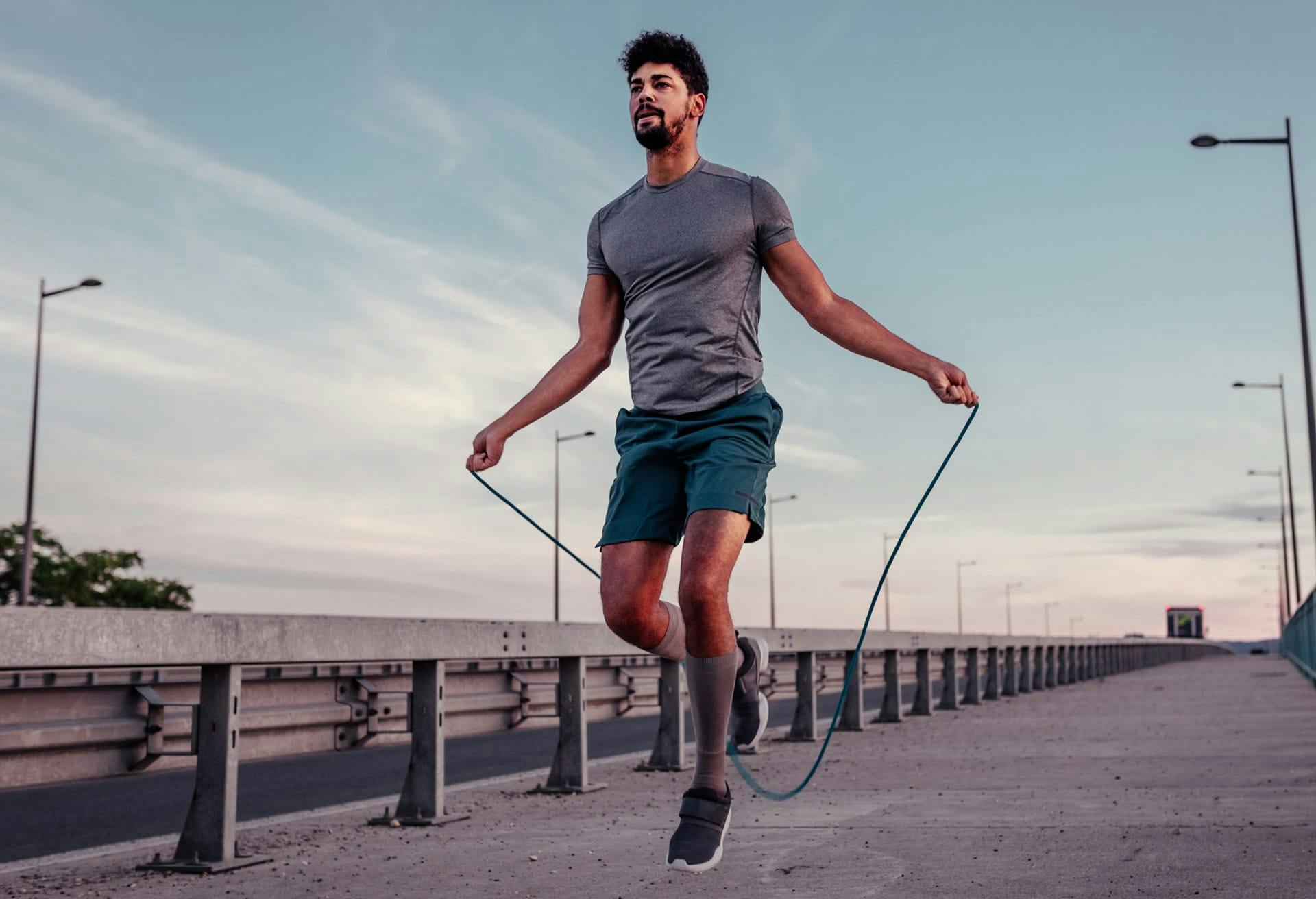 Man doing jump rope on sidewalk