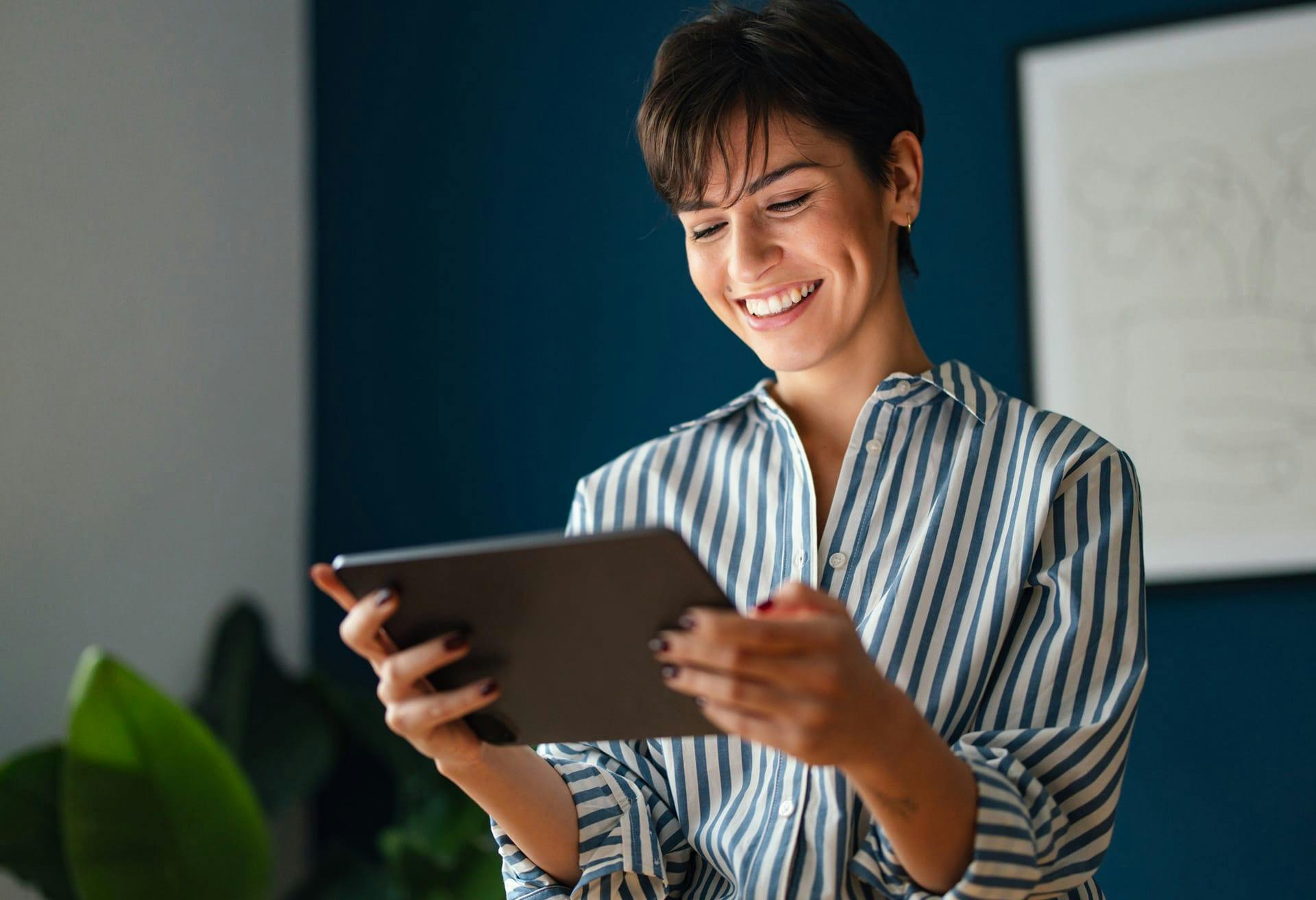 woman smiling and looking at tablet