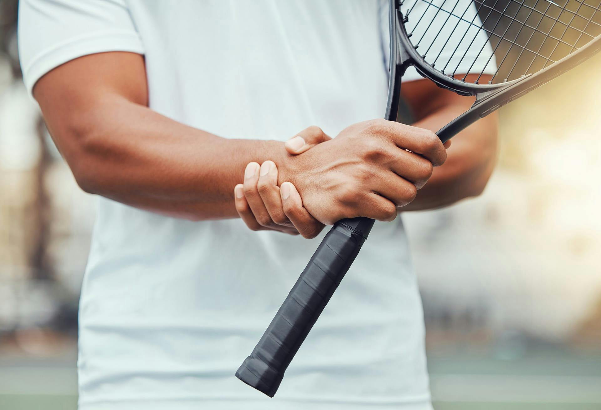 Man holding wrist in pain during tennis