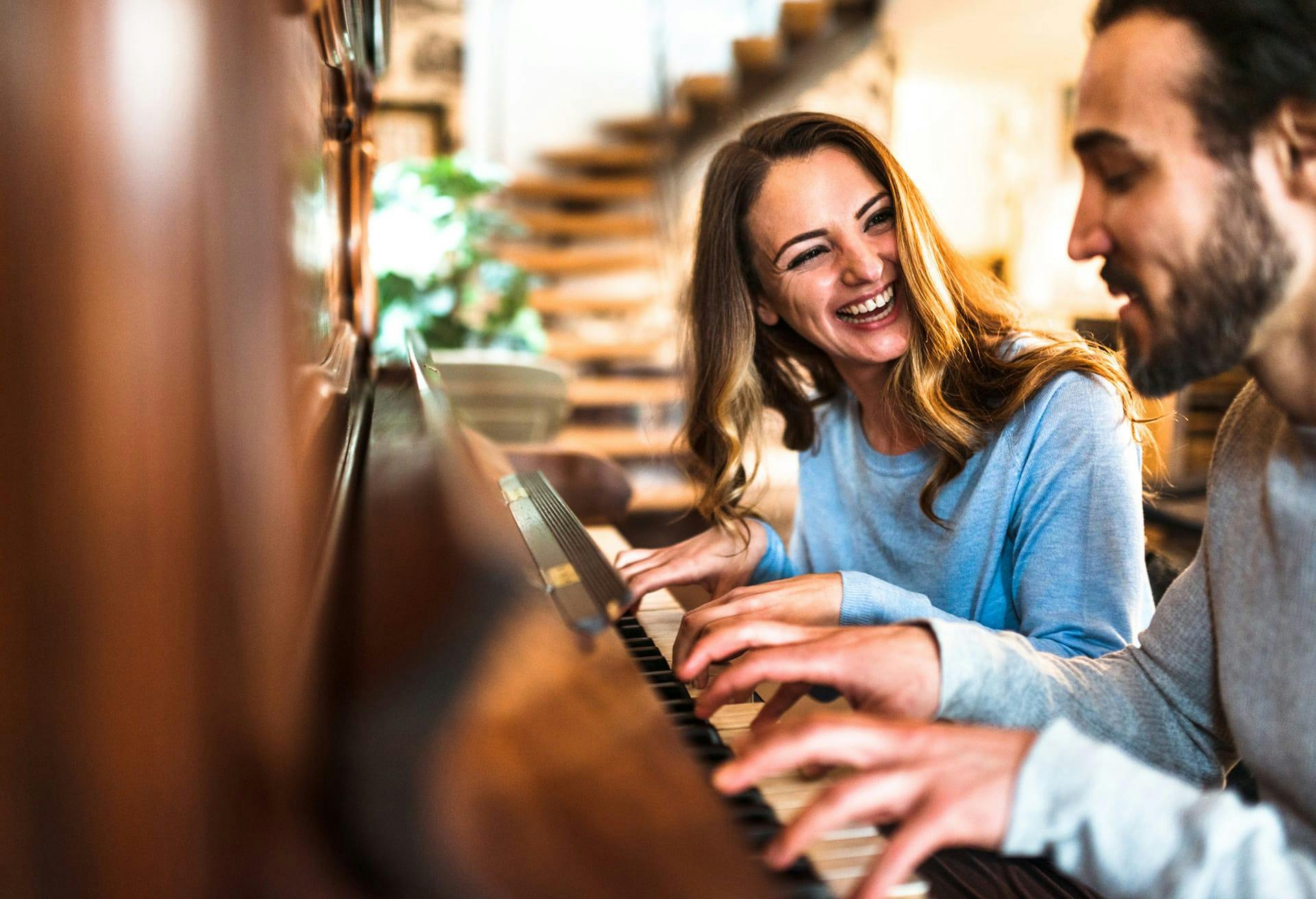 man and woman playing piano