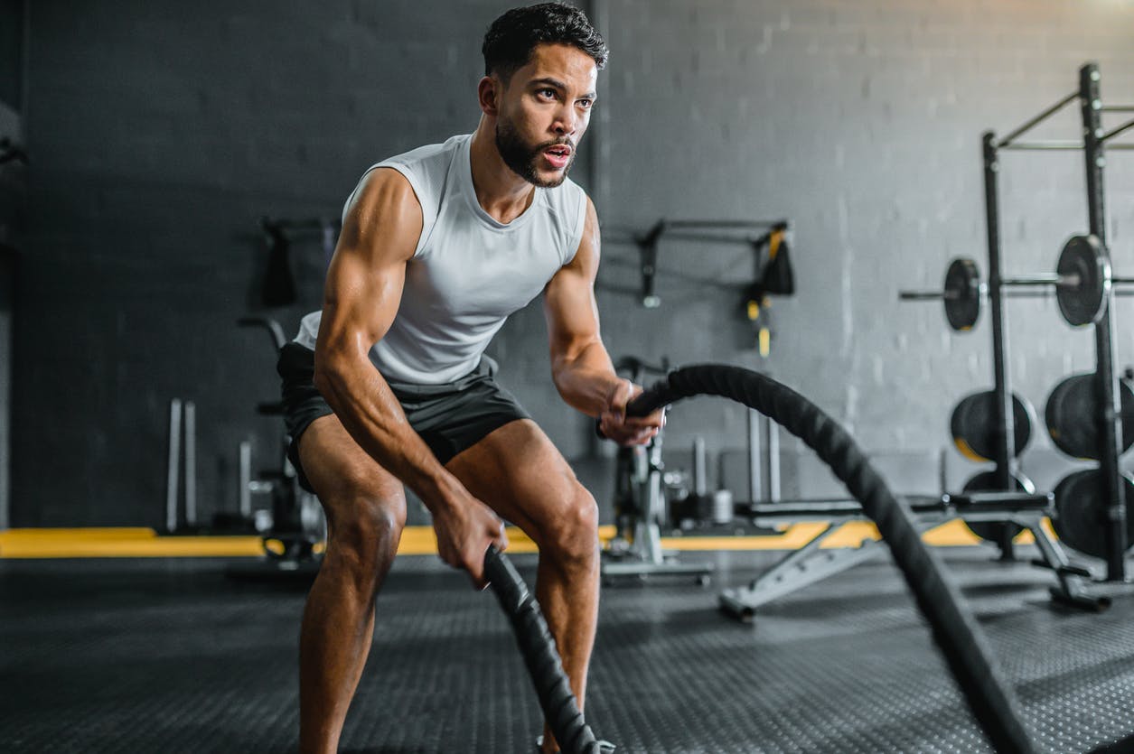Man working out with ropes shows his ability and strength in his elbows and arms