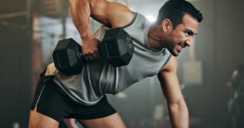 Man lifting weights and showing his ability to move his body after joint replacement surgery in Chicago