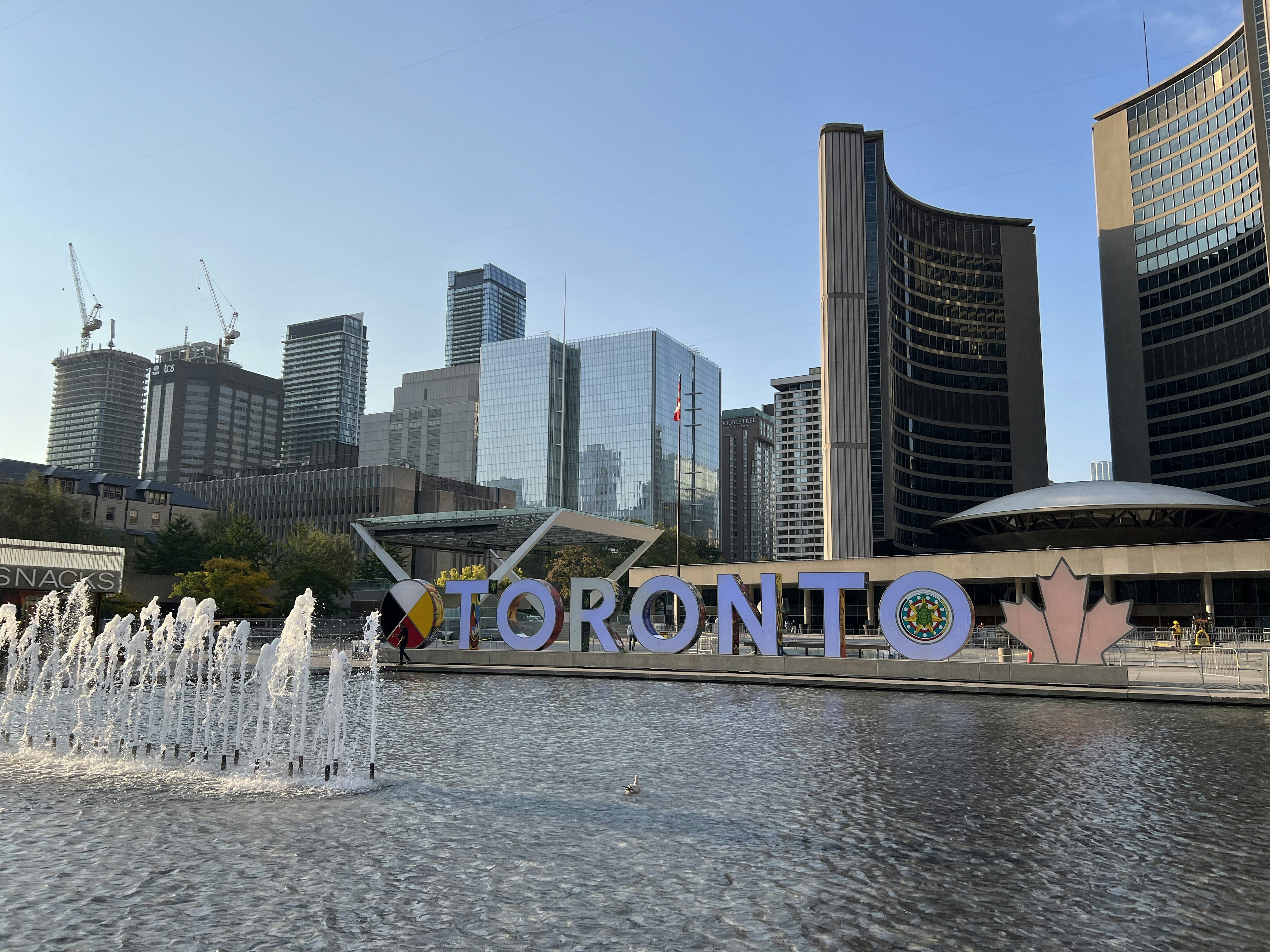 Img: city, metropolis, urban, office building, fountain, water, construction crane, person, bird, high rise