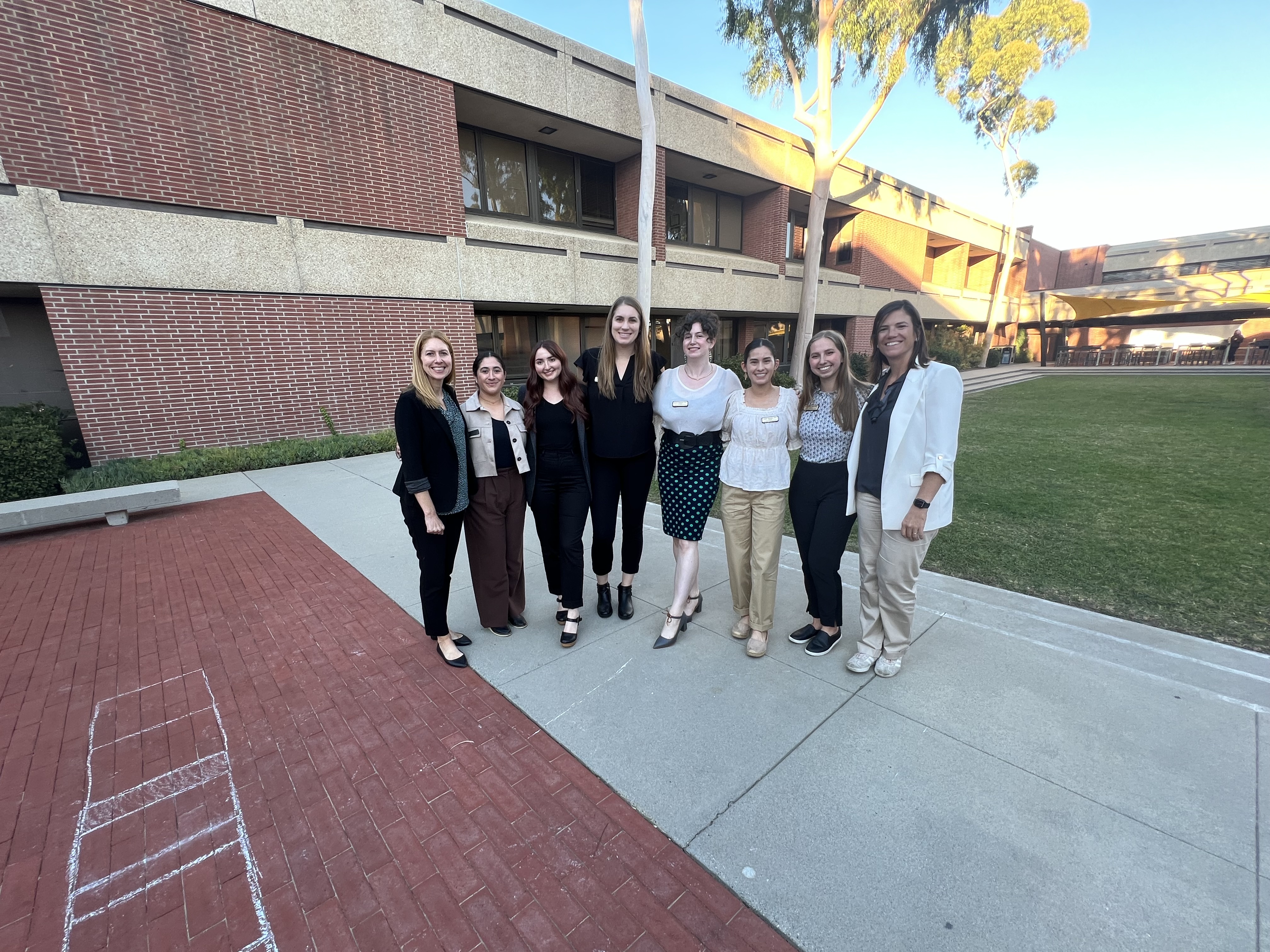 Img: college, person, wristwatch, people, skirt, shoe, pants, coat, suit, necklace