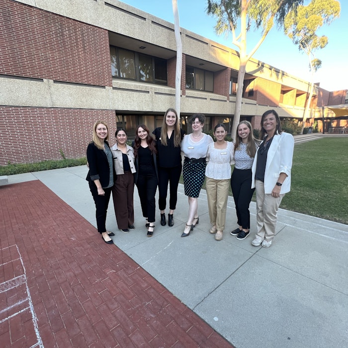 Img: college, person, wristwatch, people, skirt, shoe, pants, coat, suit, necklace