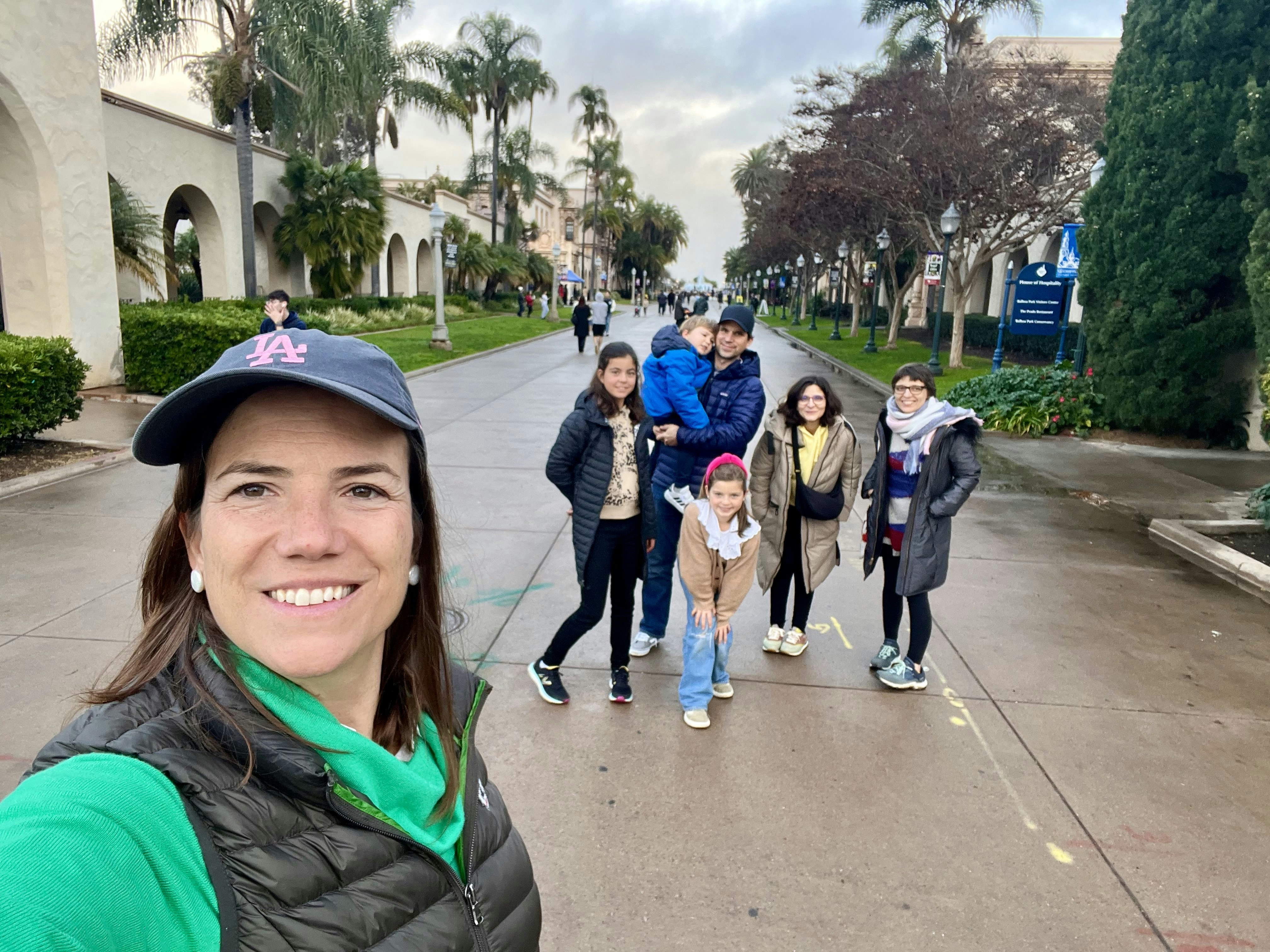 Img: walking, city, street, path, baseball cap, tree, coat, sidewalk, neighborhood, people