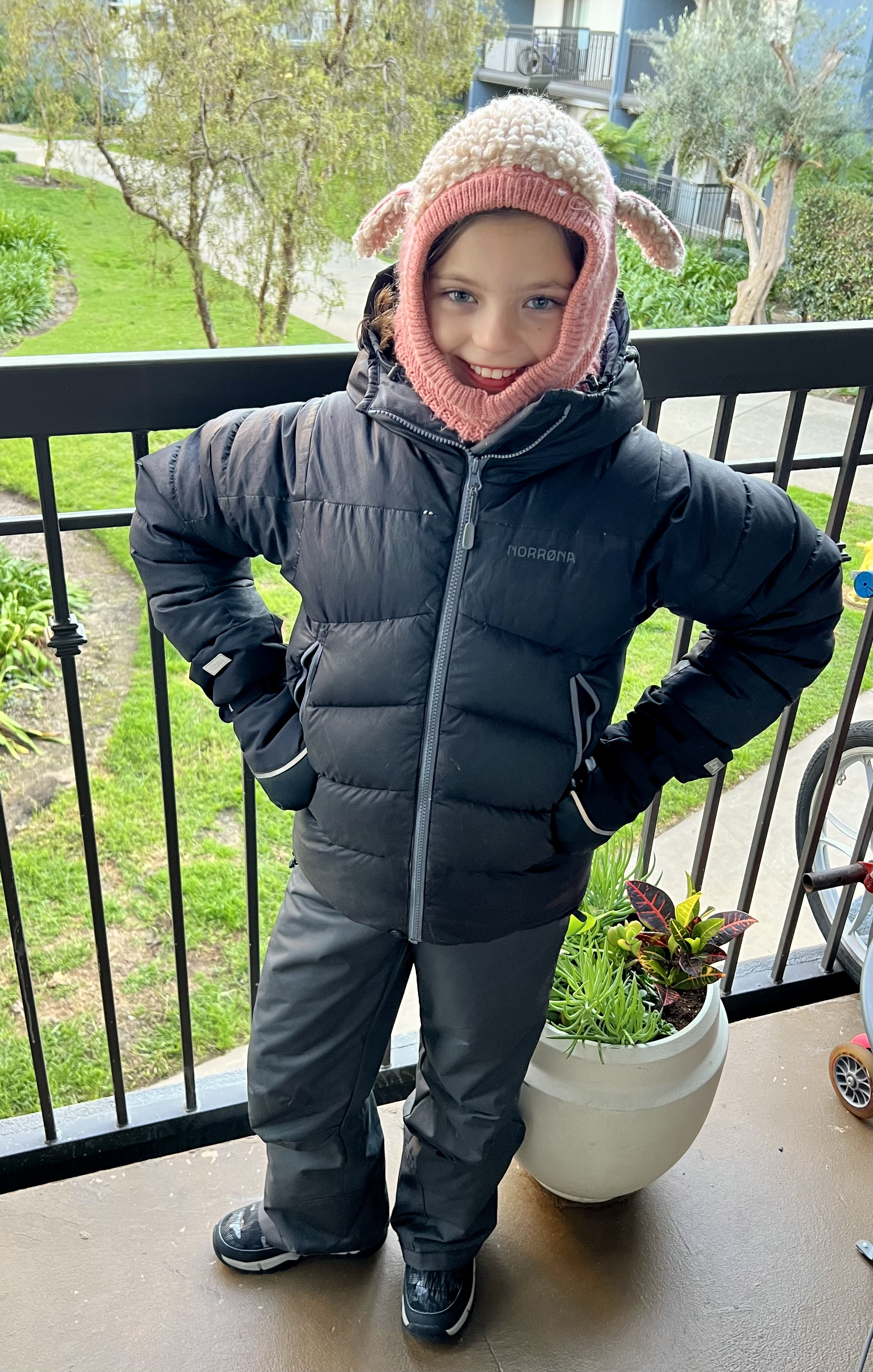 Img: clothing, coat, jacket, person, standing, hood, plant, shoe, hat, cap