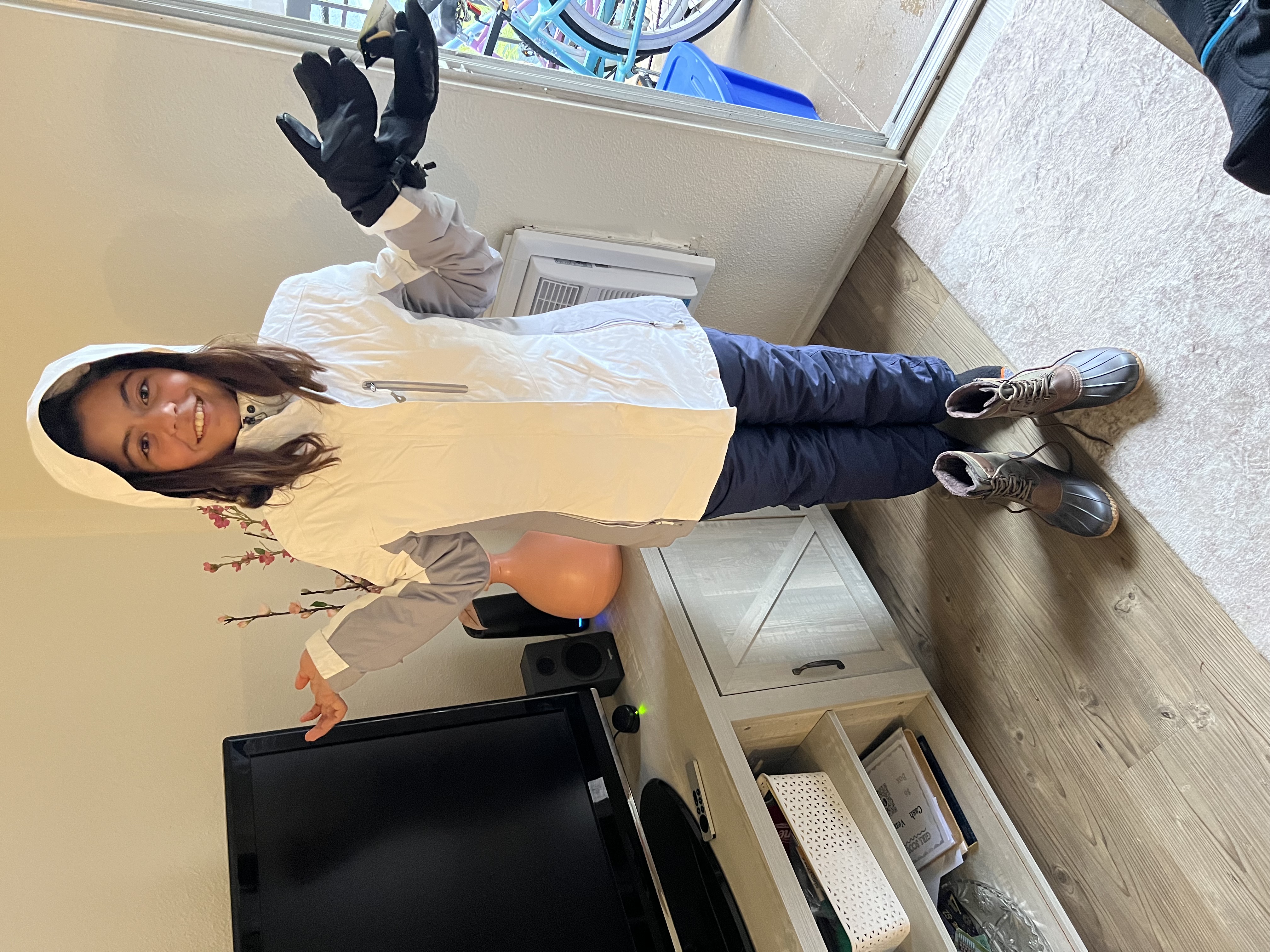 Img: person, standing, glove, female, girl, teen, speaker, monitor, shoe, coat