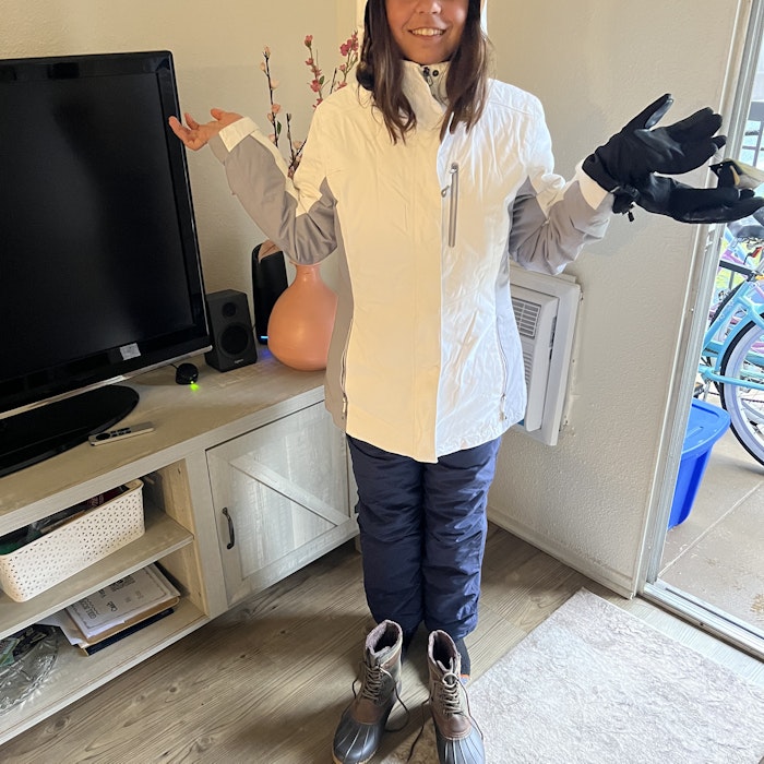 Img: person, standing, glove, female, girl, teen, speaker, monitor, shoe, coat