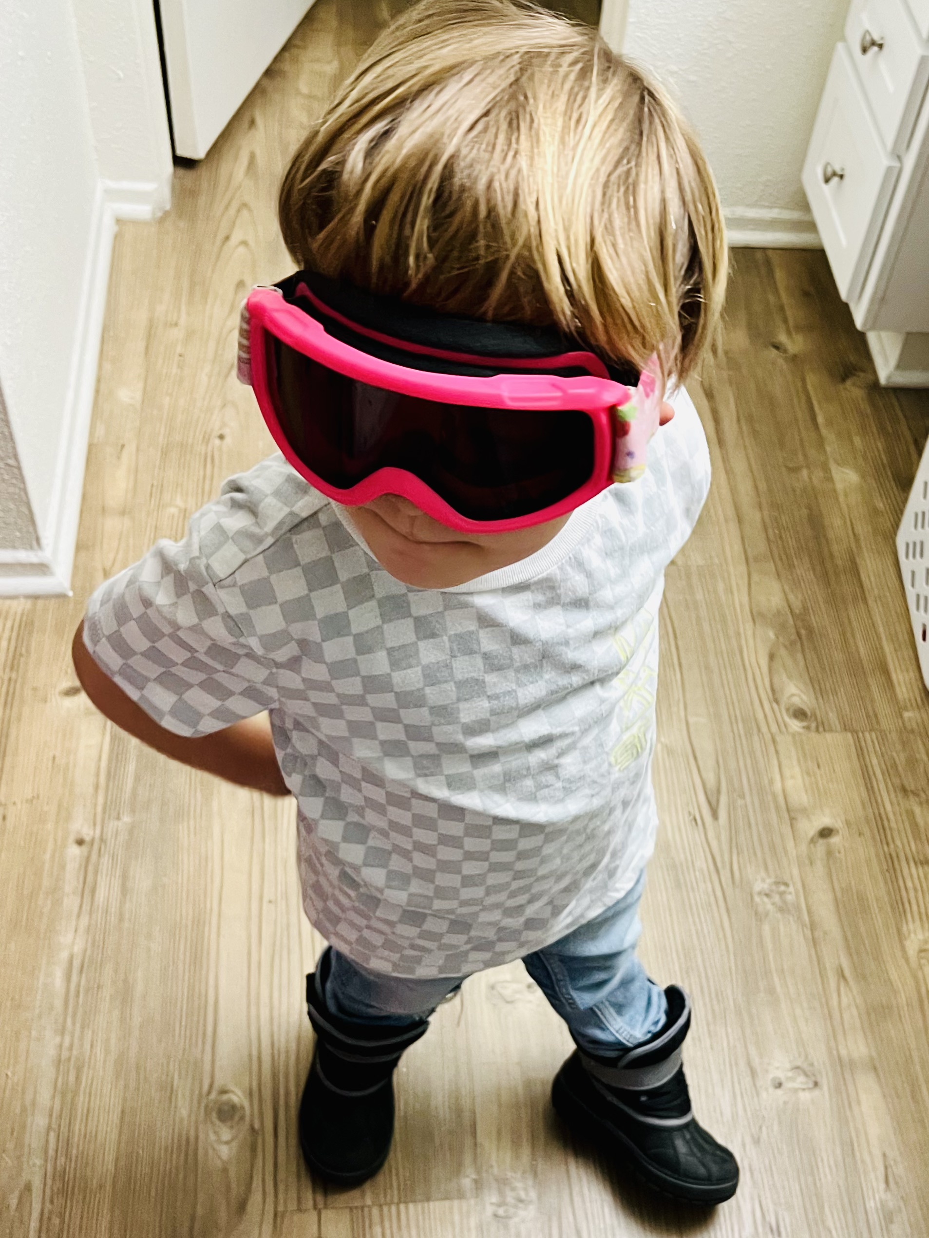 Img: accessories, goggles, sunglasses, person, floor, clothing, pants, footwear, shoe, flooring