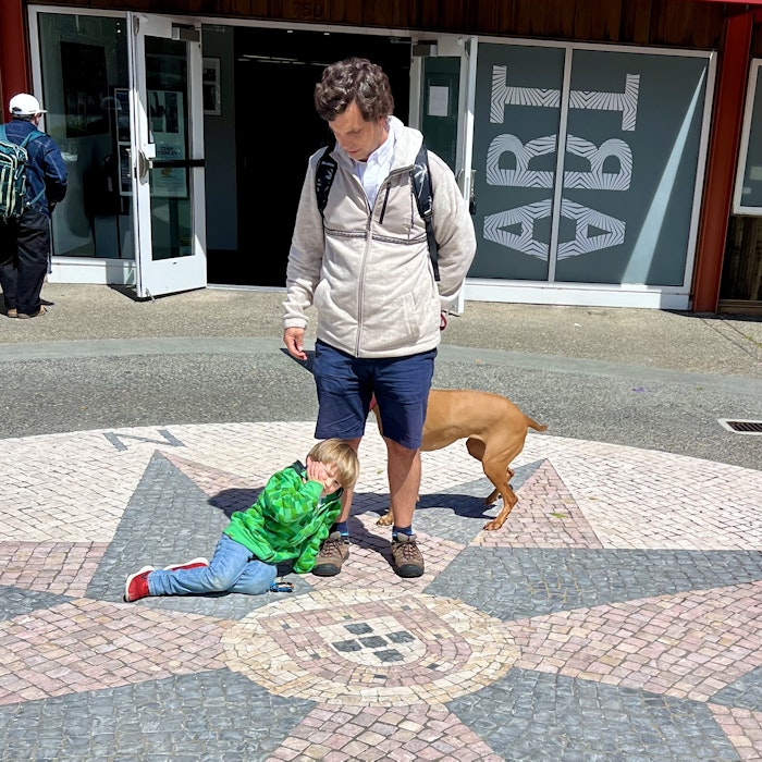 Img: path, shorts, city, street, pants, shelter, backpack, person, portrait, sidewalk