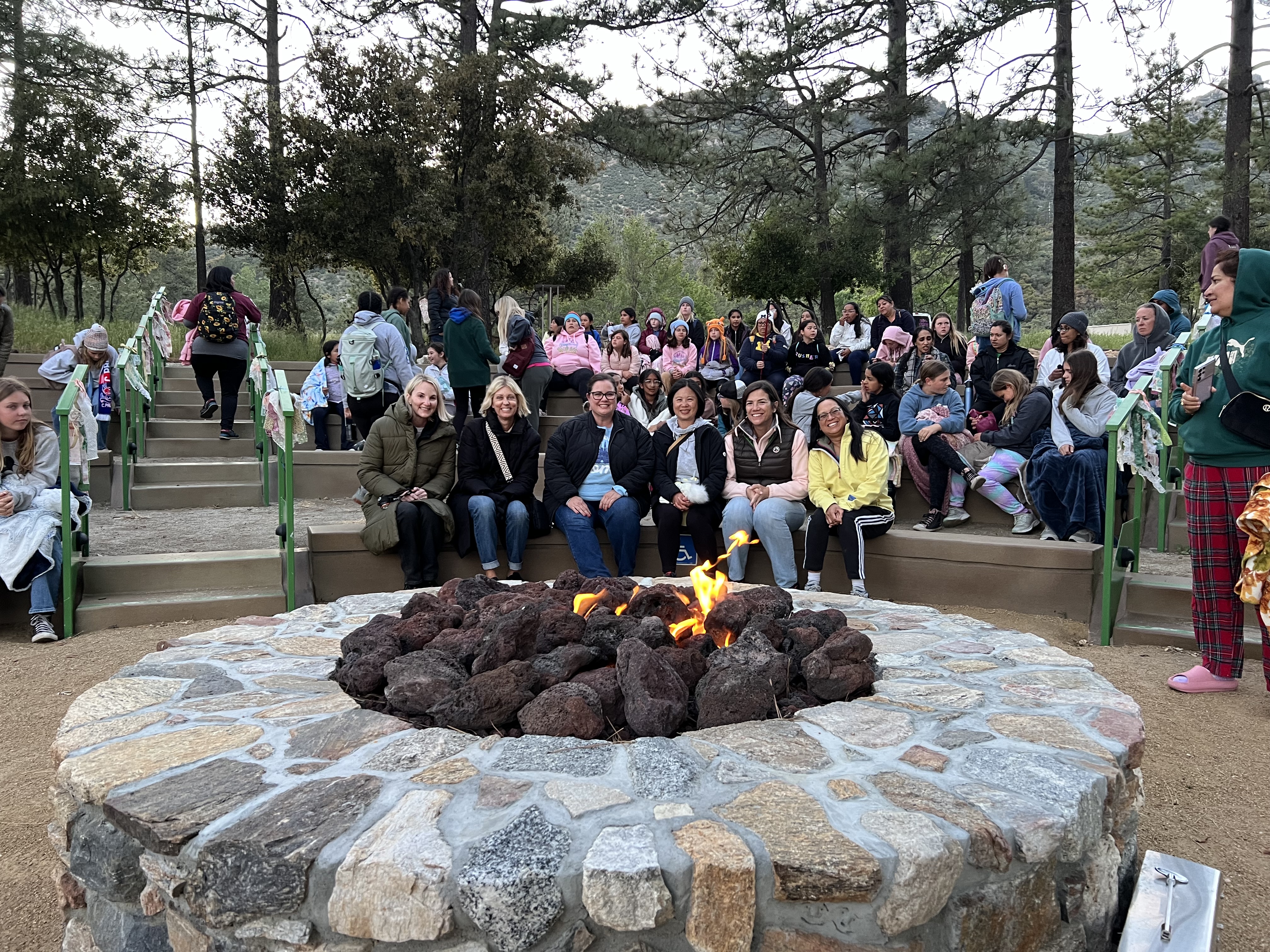 Img: park, rock, people, person, tree, flame, vegetation, pants, handbag, shoe