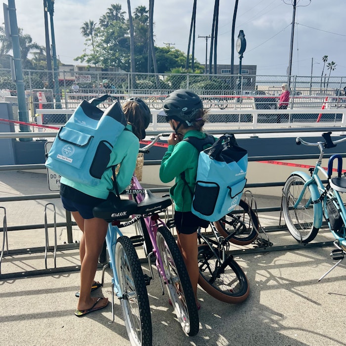 Img: helmet, backpack, bag, clothing, footwear, shoe, person, bicycle, vehicle, handbag