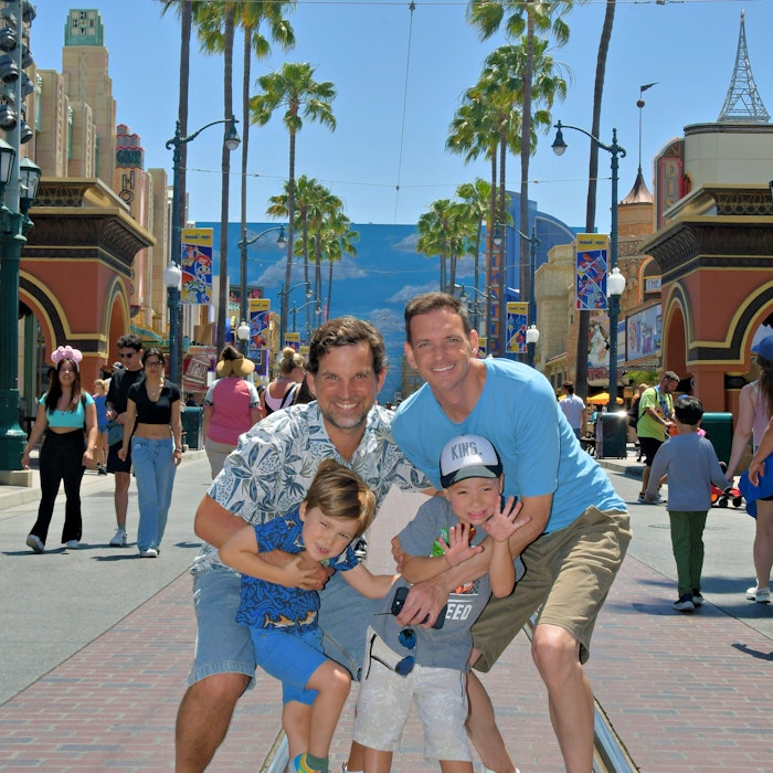 Img: shorts, path, shoe, sidewalk, tree, hat, walkway, adult, man, person