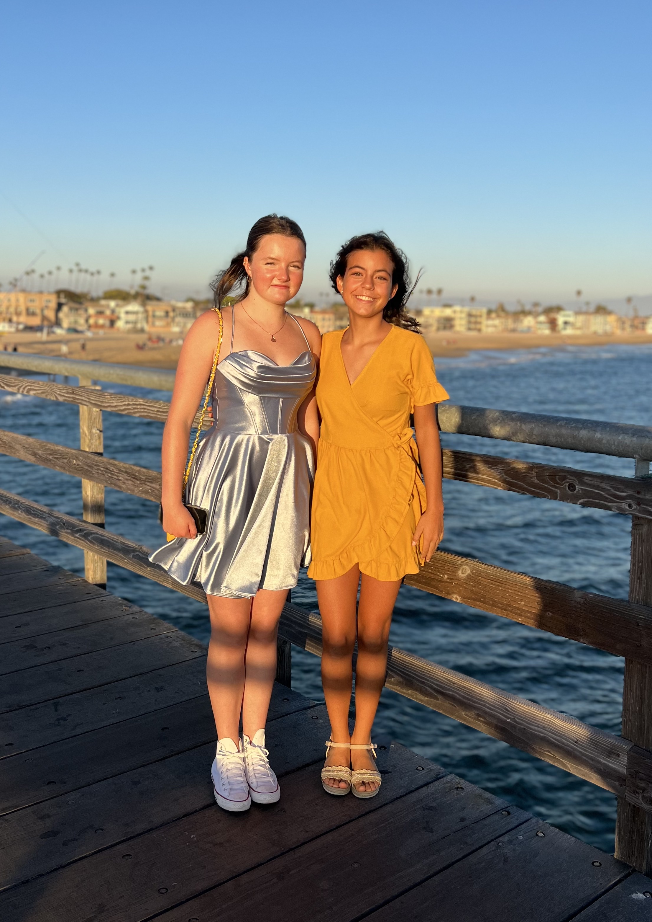 Img: waterfront, dress, evening dress, formal wear, boardwalk, pier, person, handrail, sandal, wood
