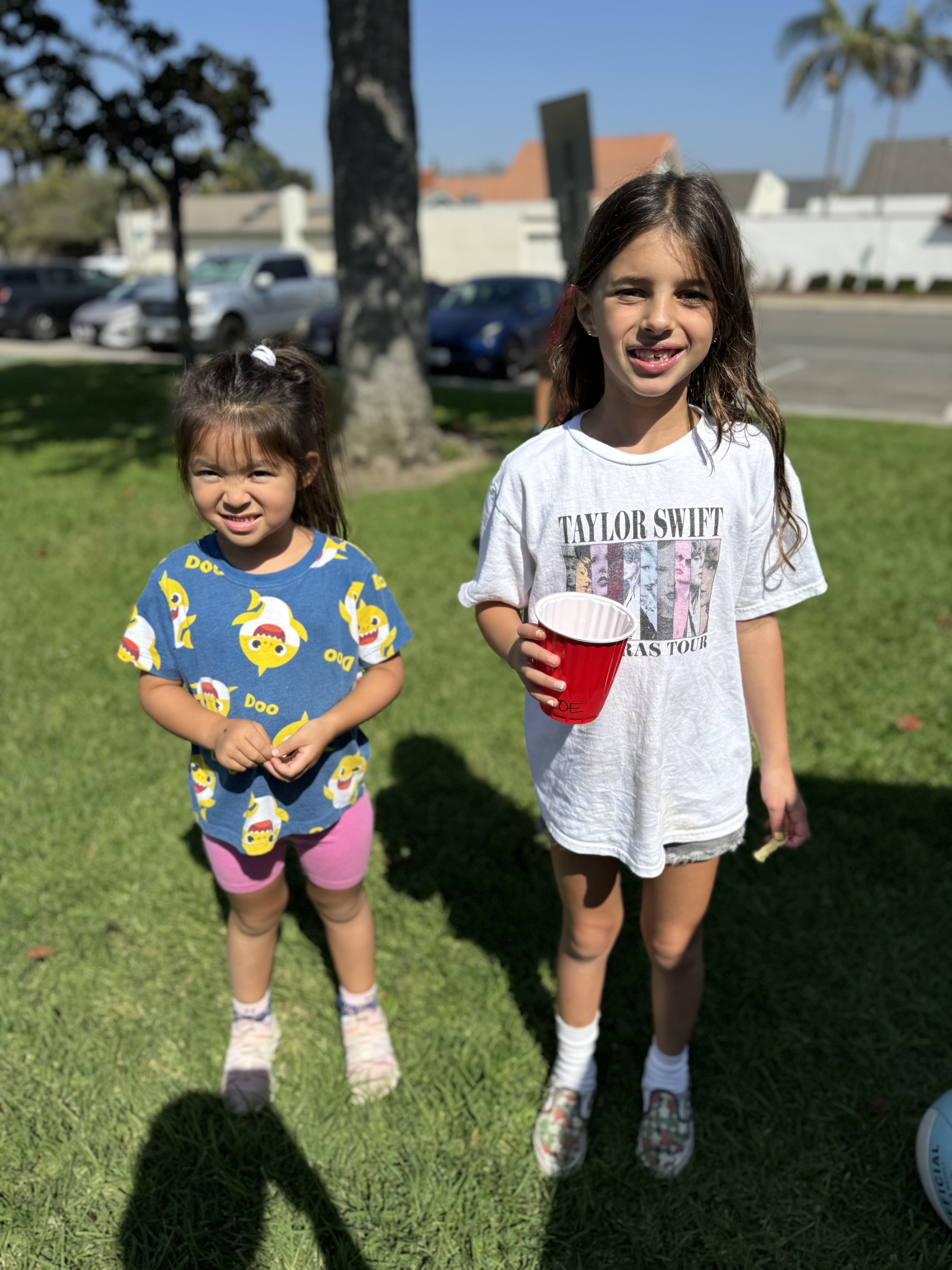Img: shorts, t-shirt, grass, child, female, girl, person, portrait, cup, shoe