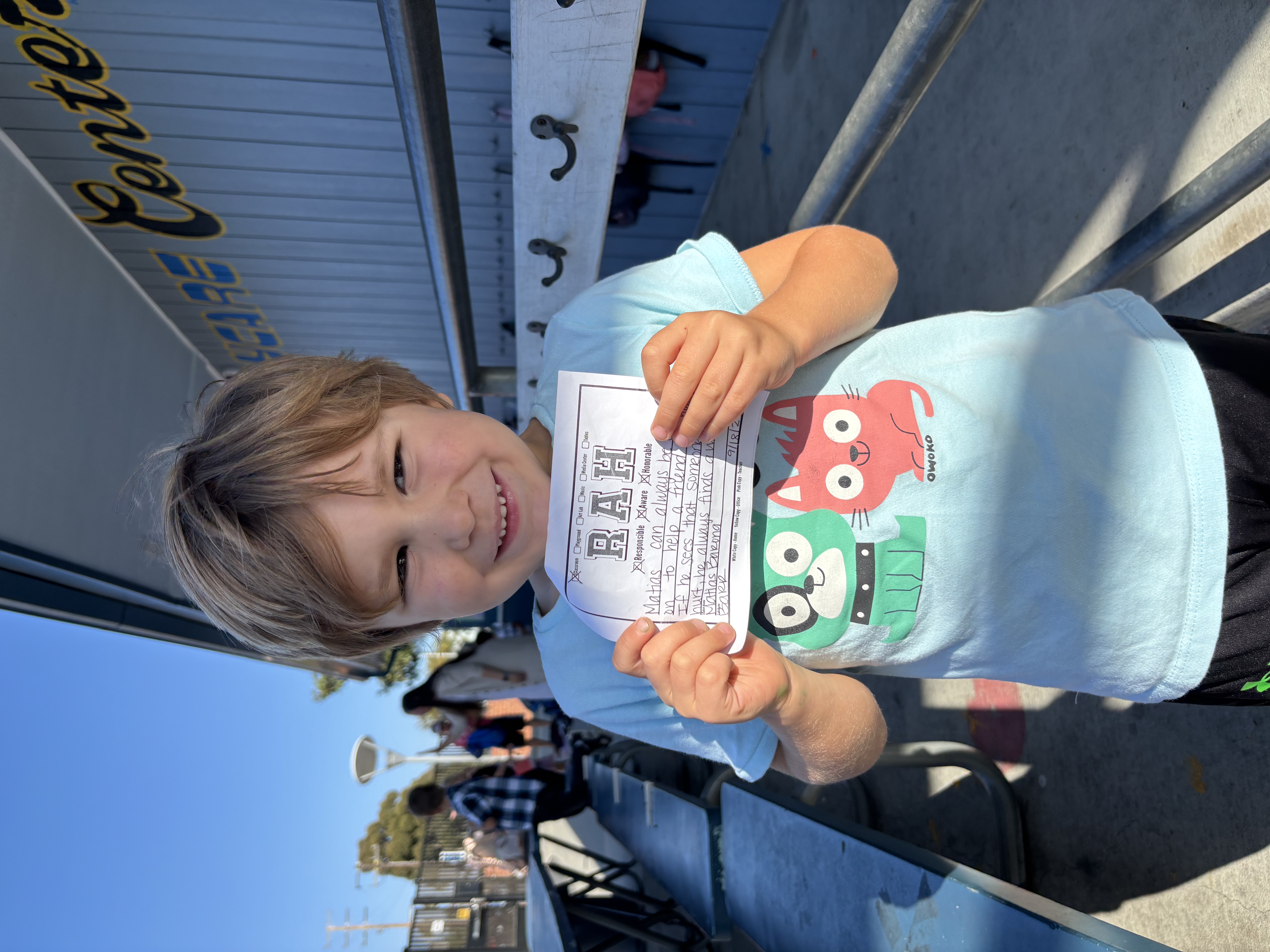 Img: t-shirt, person, photography, portrait, finger, shorts, advertisement, text, handbag, bench