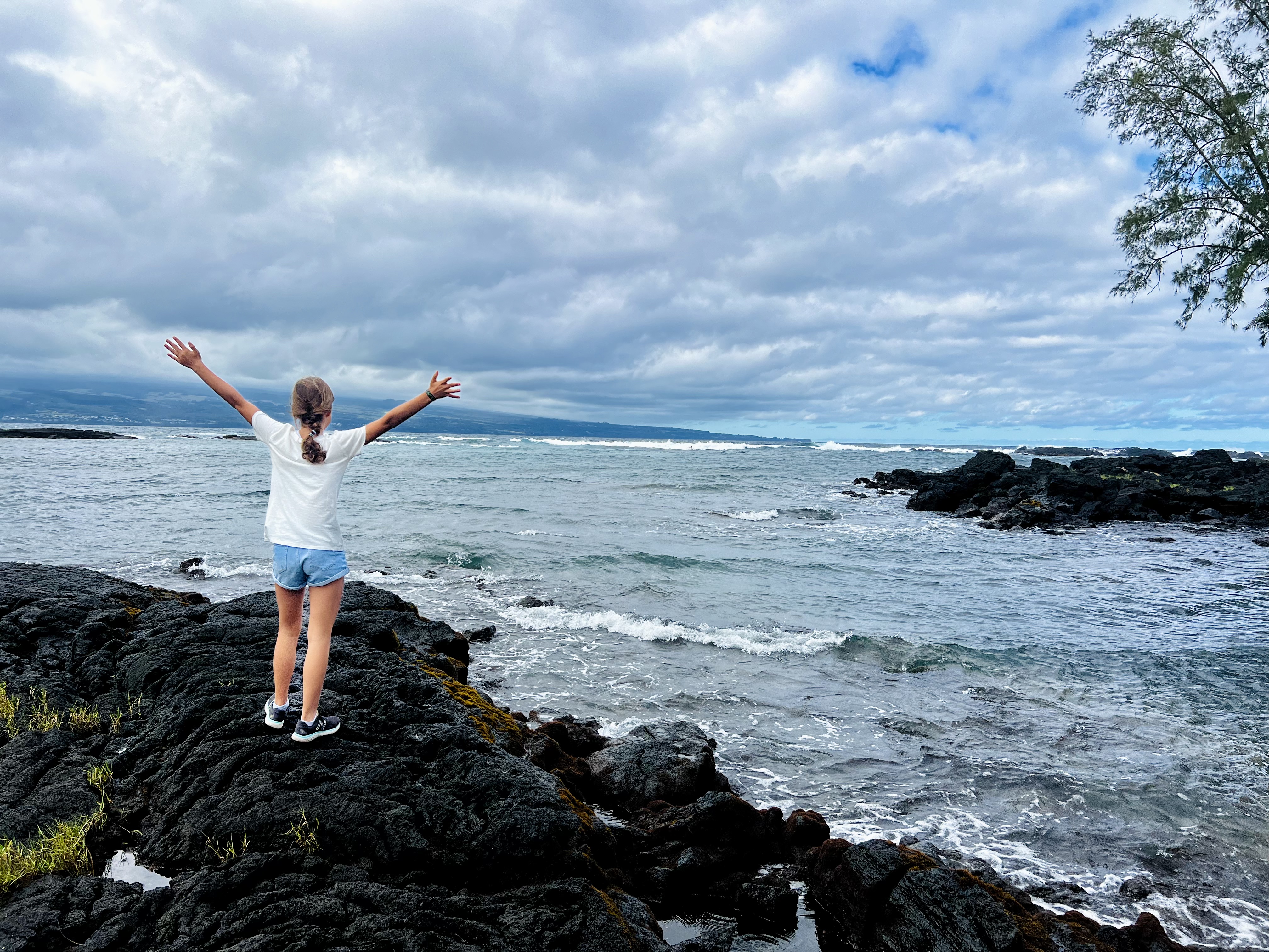 Img: face, happy, head, person, rock, shorts, shoe, triumphant, outdoors, nature