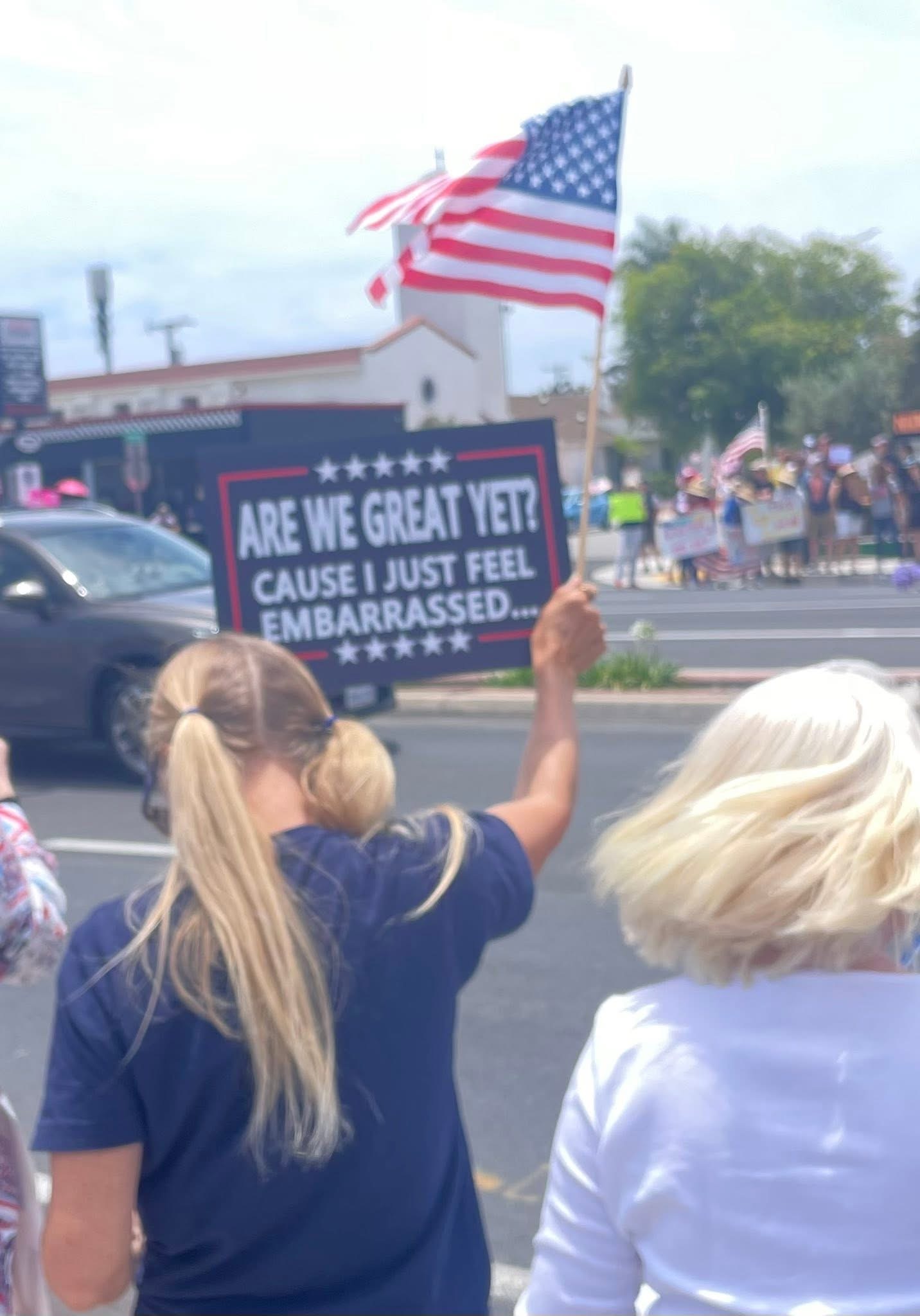 Img: flag, person, american flag, adult, female, woman, city, street, car, t-shirt